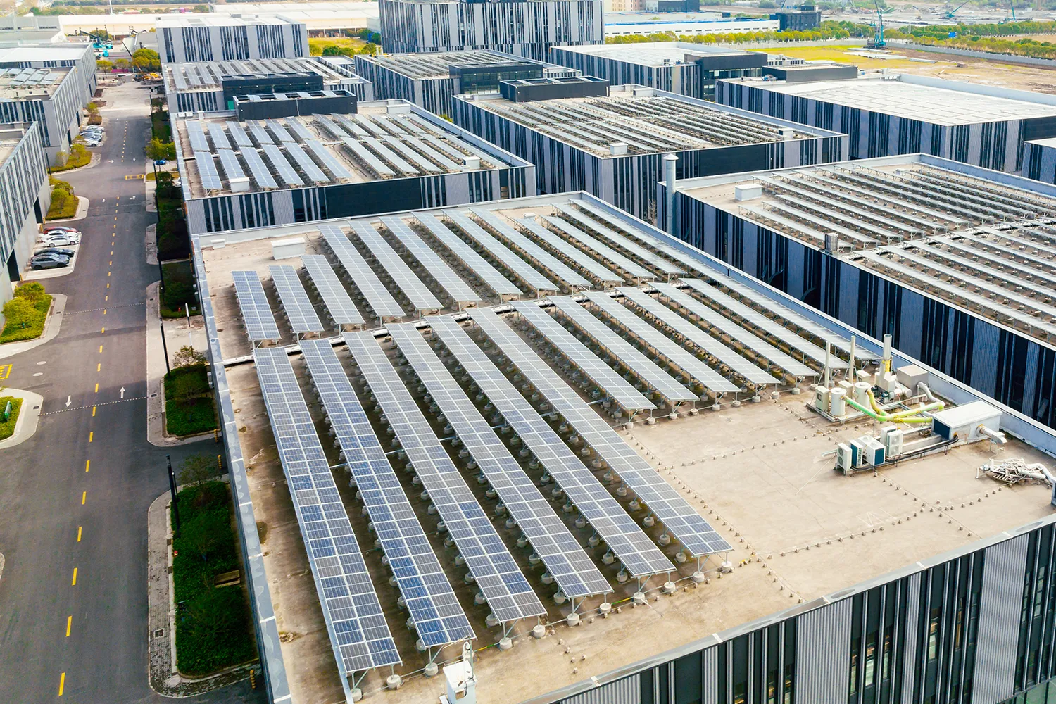 Aerial view of solar panels on factory roof. Blue shiny solar photo voltaic panels system product