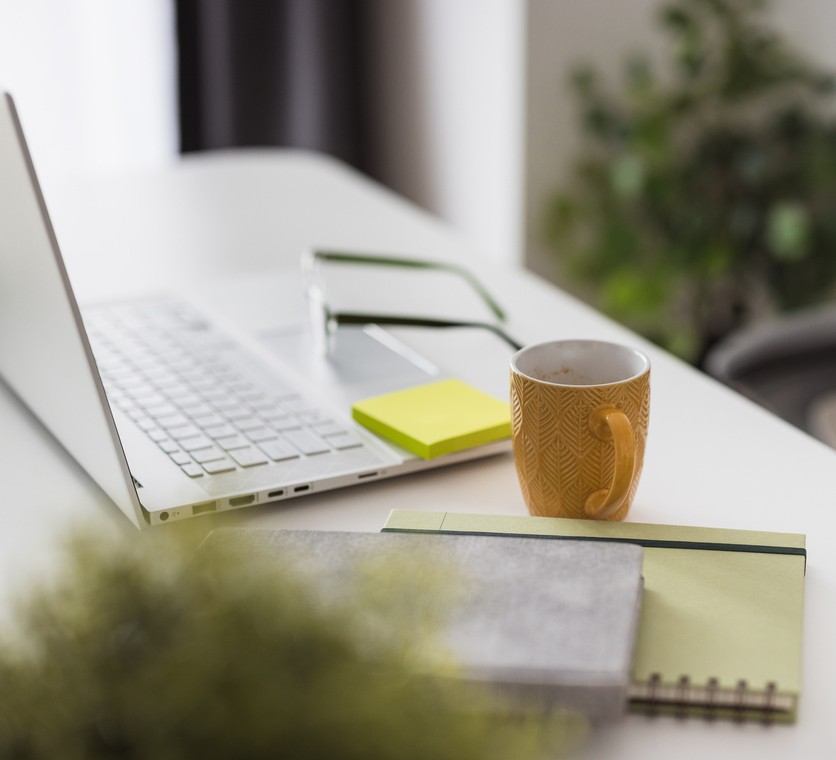 a lifestyle shot of a desktop with open laptop and a mug of coffee